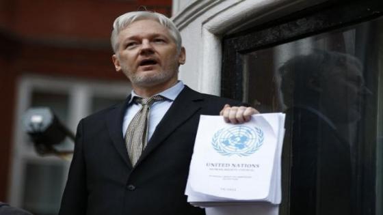 WikiLeaks founder Julian Assange holds a copy of a U.N. ruling as he makes a speech from the balcony of the Ecuadorian Embassy, in central London, Britain February 5, 2016. REUTERS/Peter Nicholls